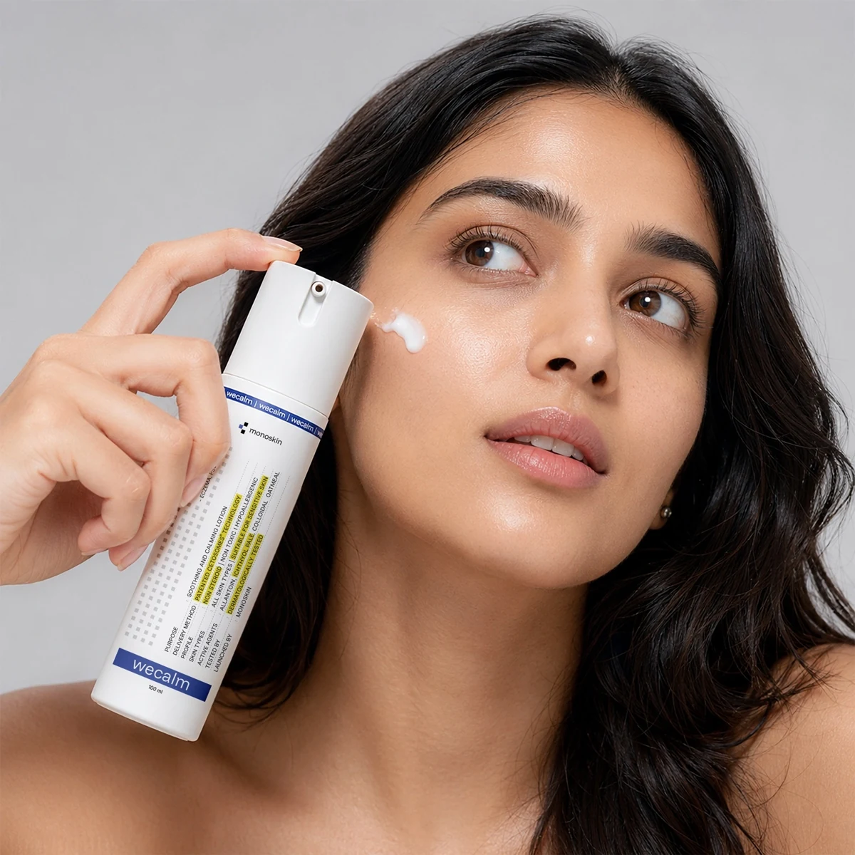Campaign portrait of a woman holding WECALM beside her cheek; illustrative, not a clinical result